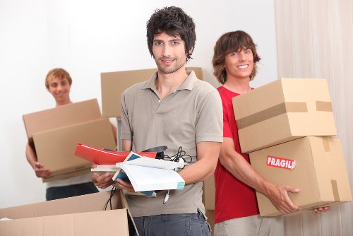 Local movers loading furniture and boxes into a van in Kingston Vale
